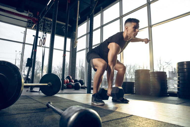 The male athlete training hard in the gym. Fitness and healthy life concept
